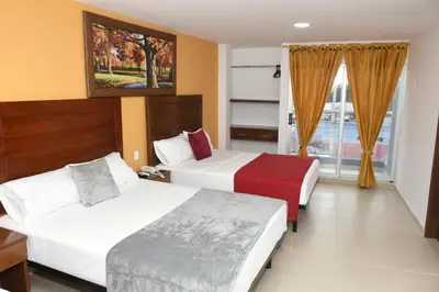 a hotel room with two beds and a window at Hotel Kai Soledad Atlántico in Soledad