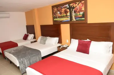 a hotel room with two beds and a painting on the wall at Hotel Kai Soledad Atlántico in Soledad