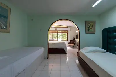 a bedroom with two beds and an arched doorway at Hostal Campomar in Santa Veronica