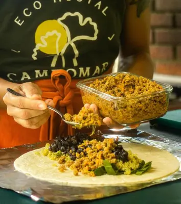 a person holding a bowl of food on a plate at Hostal Campomar in Santa Veronica