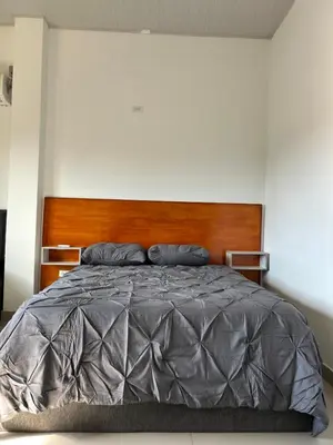 a bedroom with a large bed with a wooden headboard at ALTAVITA apart completo a 100 m del mar in Puerto Colombia