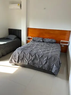 a bedroom with a bed with a wooden head board at ALTAVITA apart completo a 100 m del mar in Puerto Colombia