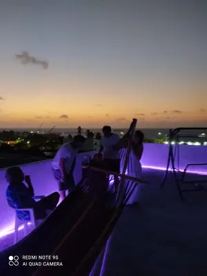 a group of people sitting on a rooftop at night at ALTAVITA apart completo a 100 m del mar in Puerto Colombia