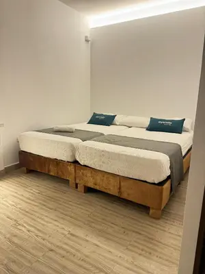 two twin beds in a room with wooden floors at Ayenda Isla de Manga in Cartagena de Indias