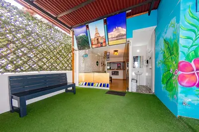 a room with a bench and a room with green carpet at Ayenda Isla de Manga in Cartagena de Indias