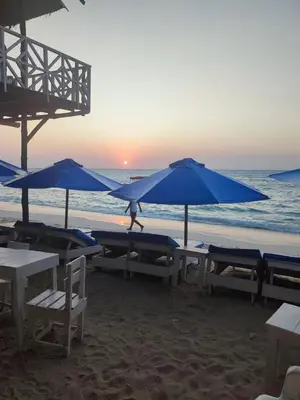 a group of tables and umbrellas on a beach at Hostal azul beach isla baru in Playa Blanca