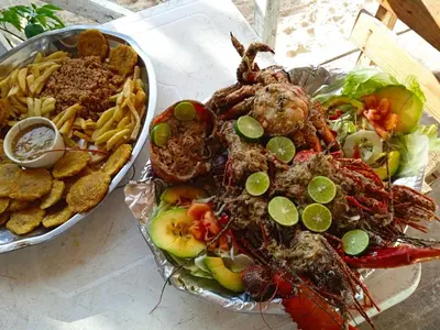 a plate of food with seafood and french fries at Hostal azul beach isla baru in Playa Blanca