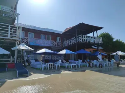 a group of tables and chairs and umbrellas on a beach at Hostal azul beach isla baru in Playa Blanca