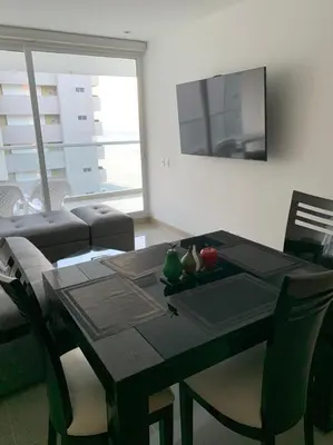 a living room with a black table and chairs at Edificio kuali apto 1704 in Santa Marta