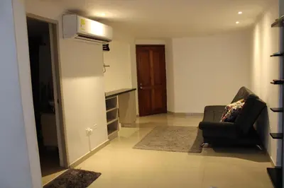 a living room with a chair and a kitchen at Apartaestudio Altamar in Cartagena de Indias