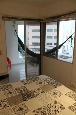a bedroom with a bed and a window with a hammock at Apartaestudio Altamar in Cartagena de Indias