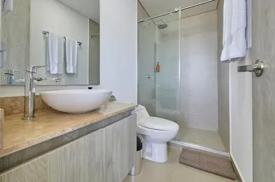 a bathroom with a sink and a toilet and a shower at Artsy Oceanview Condo W Incredible Rooftop Pool in Cartagena de Indias