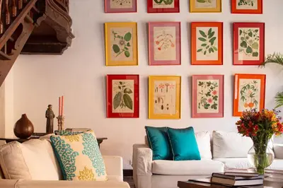 a living room with a white couch and a wall of paintings at Casa Baloco in Cartagena de Indias