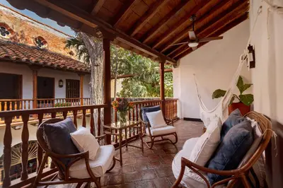 a porch with rocking chairs and a hammock at Casa Baloco in Cartagena de Indias