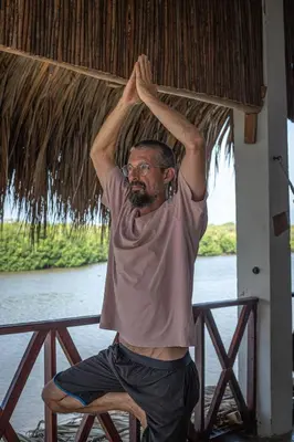 a man sitting on a chair with his arms in the air at Hostal Casa en la Ciénaga Rincon del Mar in Rincón