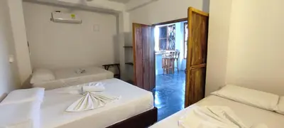a room with two beds and a room with a window at Hostal Casa en la Ciénaga Rincon del Mar in Rincón