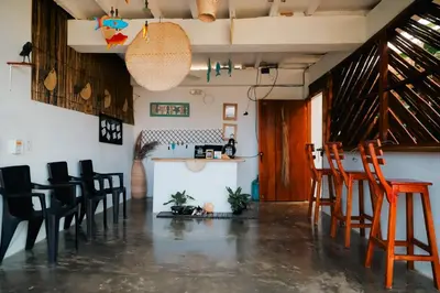 a room with chairs and a bar in it at Hostal Casa en la Ciénaga Rincon del Mar in Rincón