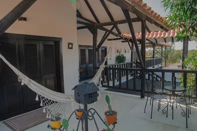 a patio with a hammock and tables and chairs at Casa Ines in Santa Marta