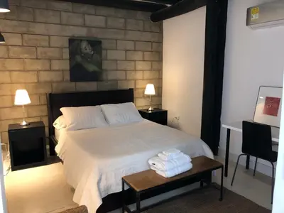 a bedroom with a bed and a table with towels on it at Casa Ines in Santa Marta