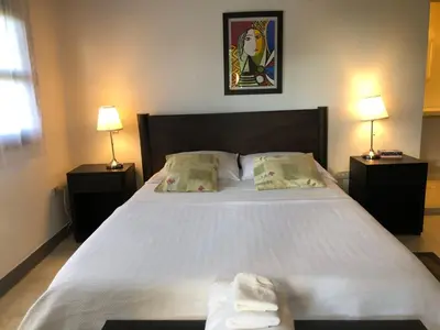 a bedroom with a large white bed with two lamps at Casa Ines in Santa Marta