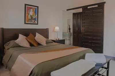 a bedroom with a large bed and a table at Casa Ines in Santa Marta