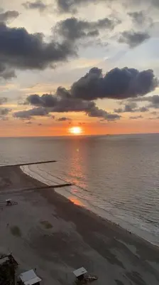 a sunset on the beach with the sun setting at Apartamento exclusivo frente al mar en Bocagrande in Cartagena de Indias