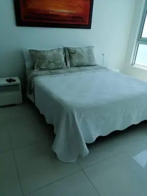 a bedroom with a bed with a white blanket at Apartamento exclusivo frente al mar en Bocagrande in Cartagena de Indias