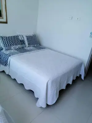 a bed in a white room with a white at Apartamento exclusivo frente al mar en Bocagrande in Cartagena de Indias