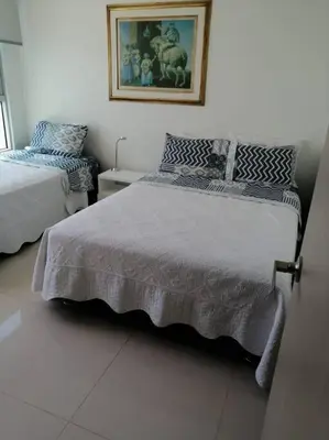 a bedroom with two beds and a picture on the wall at Apartamento exclusivo frente al mar en Bocagrande in Cartagena de Indias