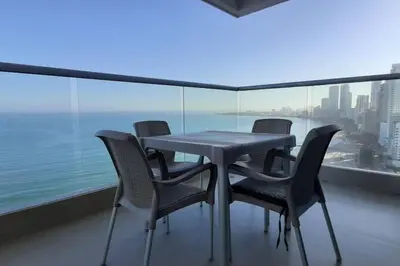 a table and chairs on a balcony with a view of the city at Apartamento exclusivo frente al mar en Bocagrande in Cartagena de Indias