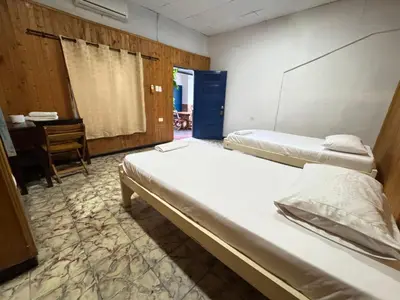 two beds in a room with a desk and a table at Hostal Luna Llena Getsemaní in Cartagena de Indias