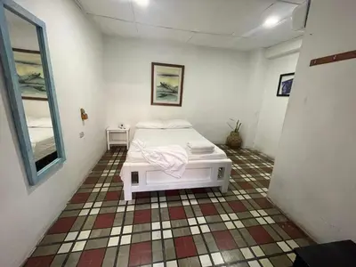 a bedroom with a white bed in a room at Hostal Luna Llena Getsemaní in Cartagena de Indias