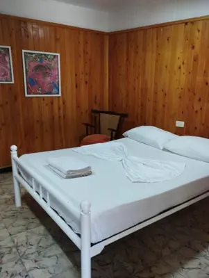 a white bed in a room with wooden walls at Hostal Luna Llena Getsemaní in Cartagena de Indias