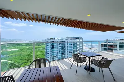 a balcony with a table and chairs and a building at 2 Dormitorios Jacuzzi y Vista Mar. Frente a playa in Cartagena de Indias