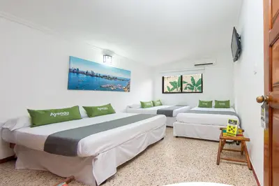 two beds in a room with white walls at Hotel Ayenda Casa Cano 1805 in Cartagena de Indias