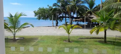 a view of a beach with palm trees and the ocean at Casa frente al mar con piscina in Coveñas