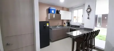 a kitchen with a black refrigerator and a table at Casa frente al mar con piscina in Coveñas