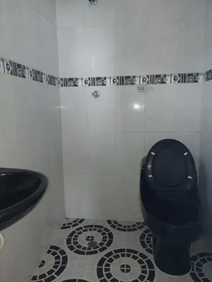 a bathroom with a black toilet and a sink at TITTO'S APARTMENT in Cartagena de Indias