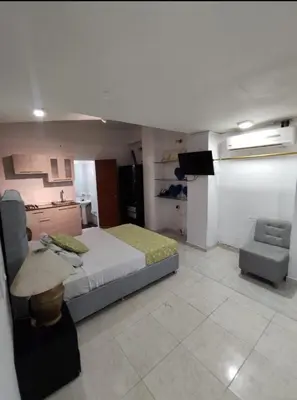 a bedroom with a bed and a tv and a chair at MR1-1G APARTAMENTO BASICO CERCA AL MAR CON AIRE ACONDICIONADO Y WIFi PARA 4 PERSONAS in Cartagena de Indias