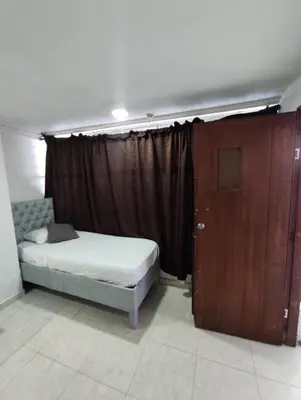 a bedroom with a bed and a wooden door at MR1-1G APARTAMENTO BASICO CERCA AL MAR CON AIRE ACONDICIONADO Y WIFi PARA 4 PERSONAS in Cartagena de Indias