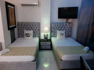 a bedroom with two beds and a flat screen tv at MR1-2G APARTAMENTO BASICO CERCA AL MAR CON AIRE ACONDICIONADO Y WIFi PARA 4 PERSONAS in Cartagena de Indias