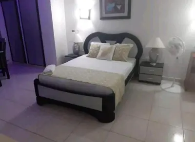 a bedroom with a bed and two lamps and a fan at MR1-2G APARTAMENTO BASICO CERCA AL MAR CON AIRE ACONDICIONADO Y WIFi PARA 4 PERSONAS in Cartagena de Indias