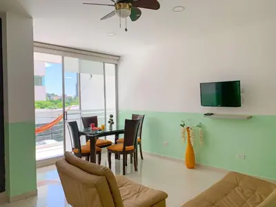 a living room with a table and chairs and a television at Hotel Cabreromar in Cartagena de Indias