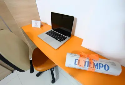 an orange desk with a laptop computer on it at Hotel Cabreromar in Cartagena de Indias