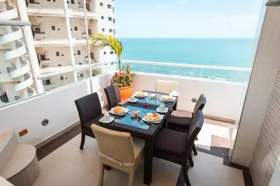 a dining room with a table and chairs and the ocean at Hotel Cabreromar in Cartagena de Indias