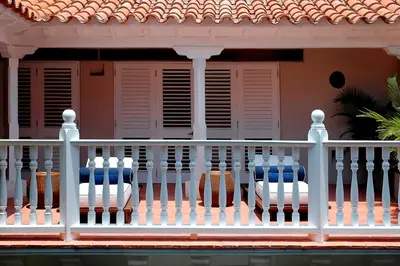two chairs on a porch with a white fence at Hotel Casa Don Sancho By Mustique in Cartagena de Indias