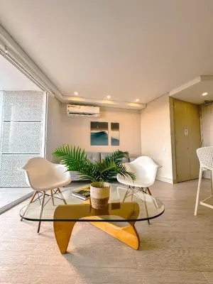 a living room with two white chairs and a table at Confortable y exclusivo apartamento en Martinique Cielo Mar in Cartagena de Indias