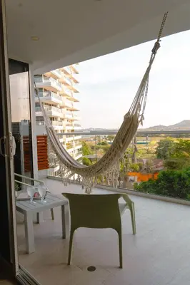 a hammock hanging in a room with a large window at Confortable y exclusivo apartamento en Martinique Cielo Mar in Cartagena de Indias