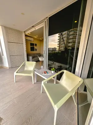 a balcony with two white chairs and a living room at Confortable y exclusivo apartamento en Martinique Cielo Mar in Cartagena de Indias