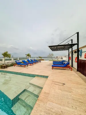 a row of blue lounge chairs next to a swimming pool at Confortable y exclusivo apartamento en Martinique Cielo Mar in Cartagena de Indias